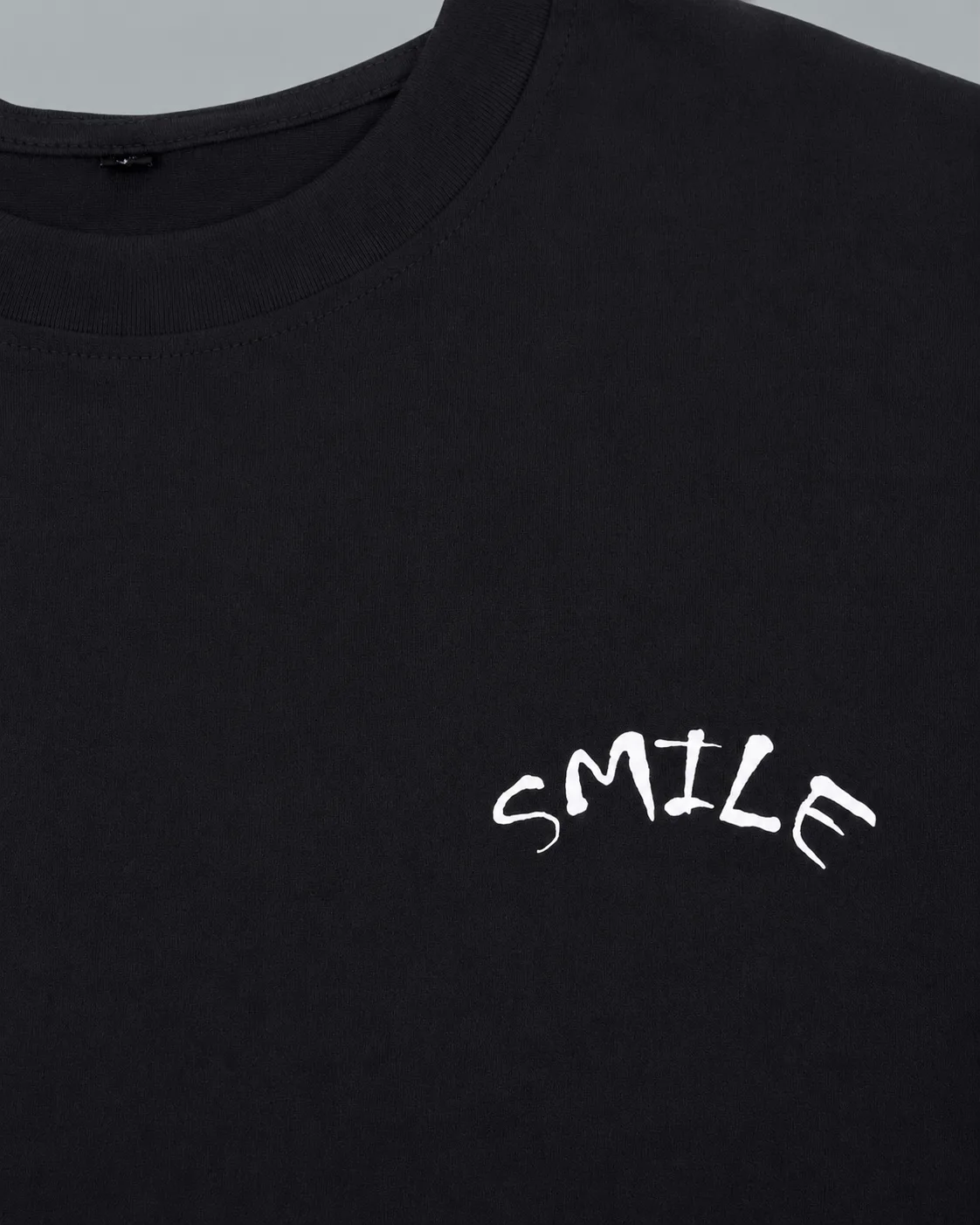 THE SMILY T-SHIRT باللون الأسود — تفاصيل القماش 1